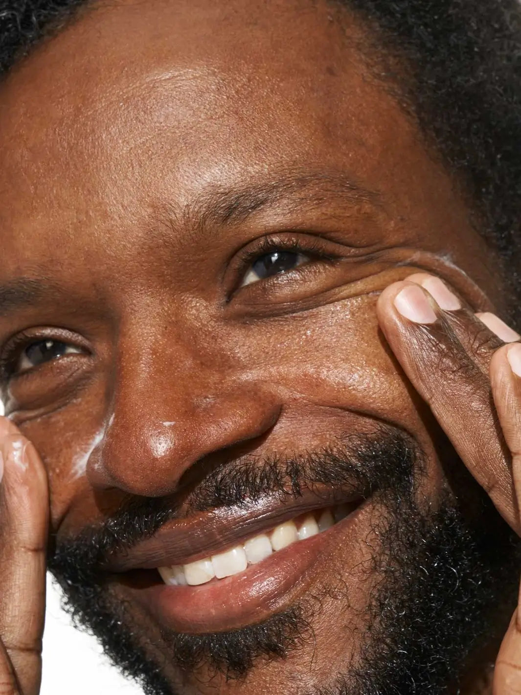 Close-up of a man applying Doré Skincare 'La Crème All-in-One Daily Moisturizer' to his face | Twentyseven Toronto