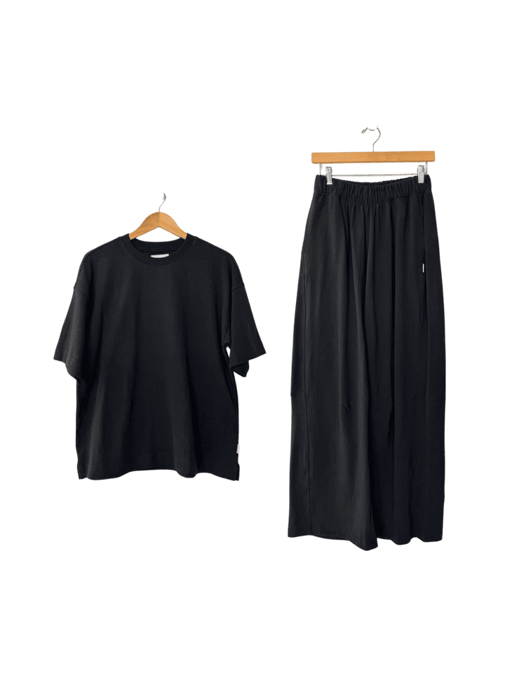 Le Bon Shoppe Jayden Tee in 'black' t-shirt and Bare Pants in 'black' wide-leg pants on hangers | Twentyseven Toronto