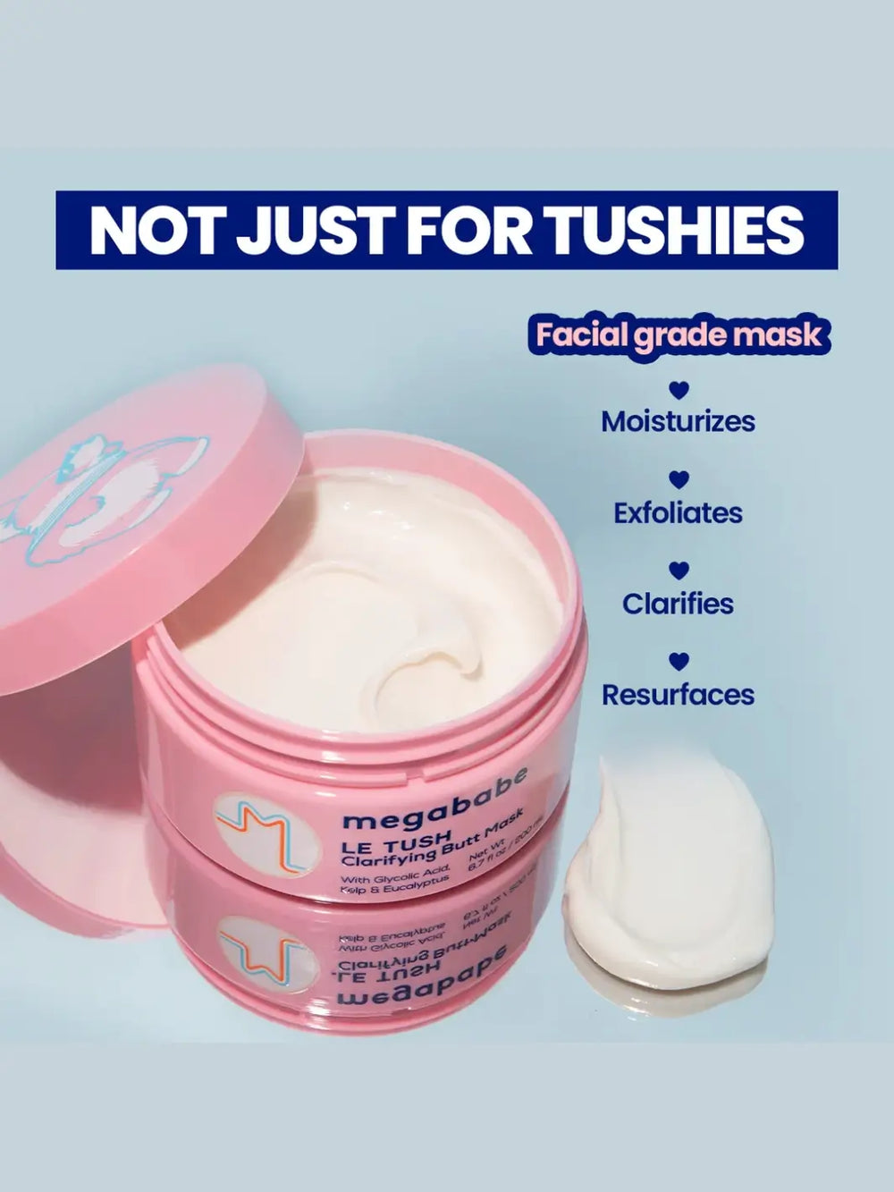 An open pink jar of Megababe Le Tush Butt Mask sits on a reflective surface next to a dollop of white cream, showcasing its texture alongside text highlighting benefits like moisturizing and exfoliating | Twentyseven Toronto