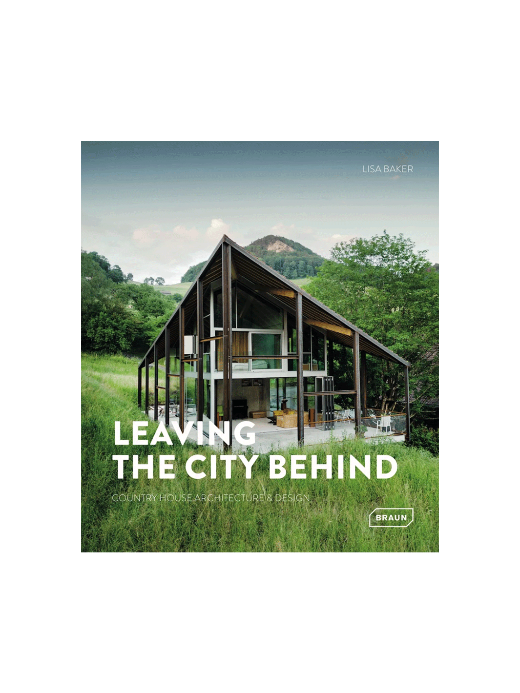 Book cover for 'Leaving the City Behind: Country House Architecture & Design' by Lisa Baker, featuring a large modern open-frame house with a steep gable roof in a grassy, mountainous landscape | Twentyseven Toronto