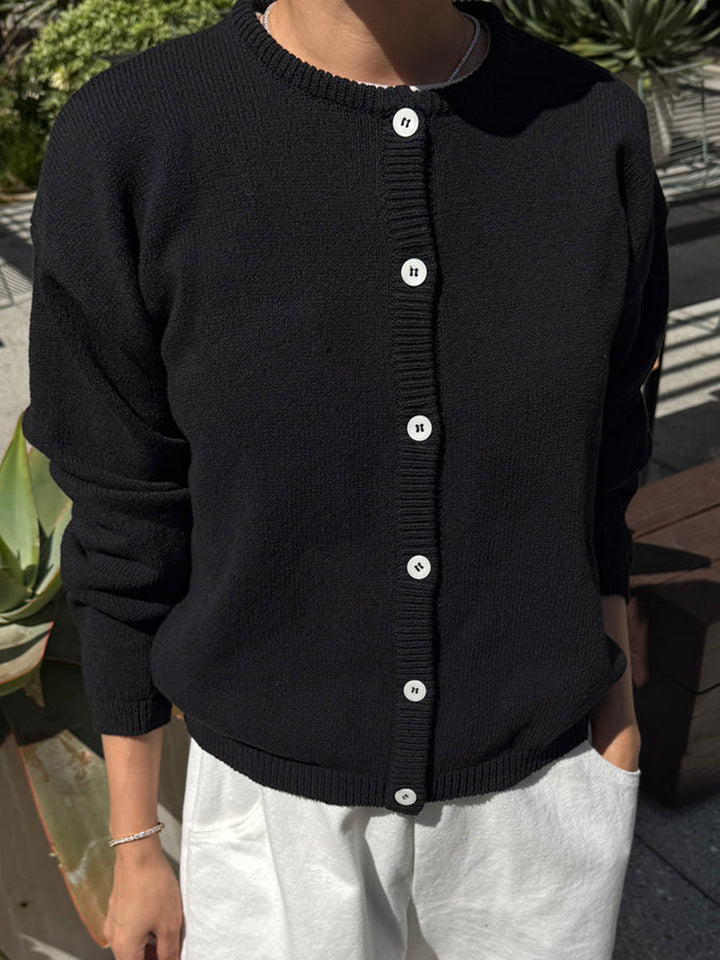 Model wearing the Le Bon Shoppe Laila Cardigan in Black buttoned with white pants | Twentyseven Toronto