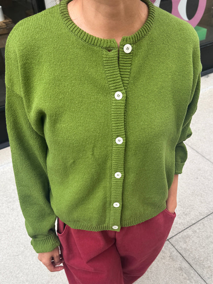 Front view of the Leila Cotton Cardigan in Avocado, styled with burgundy pants | Twentyseven Toronto
