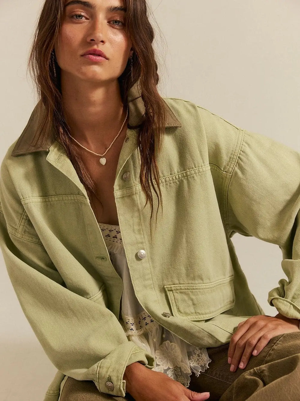 A close-up studio shot highlights the metallic button closures and contrasting collar texture of the Free People Lemon Denim Jacket in Washed Sage | Twentyseven Toronto