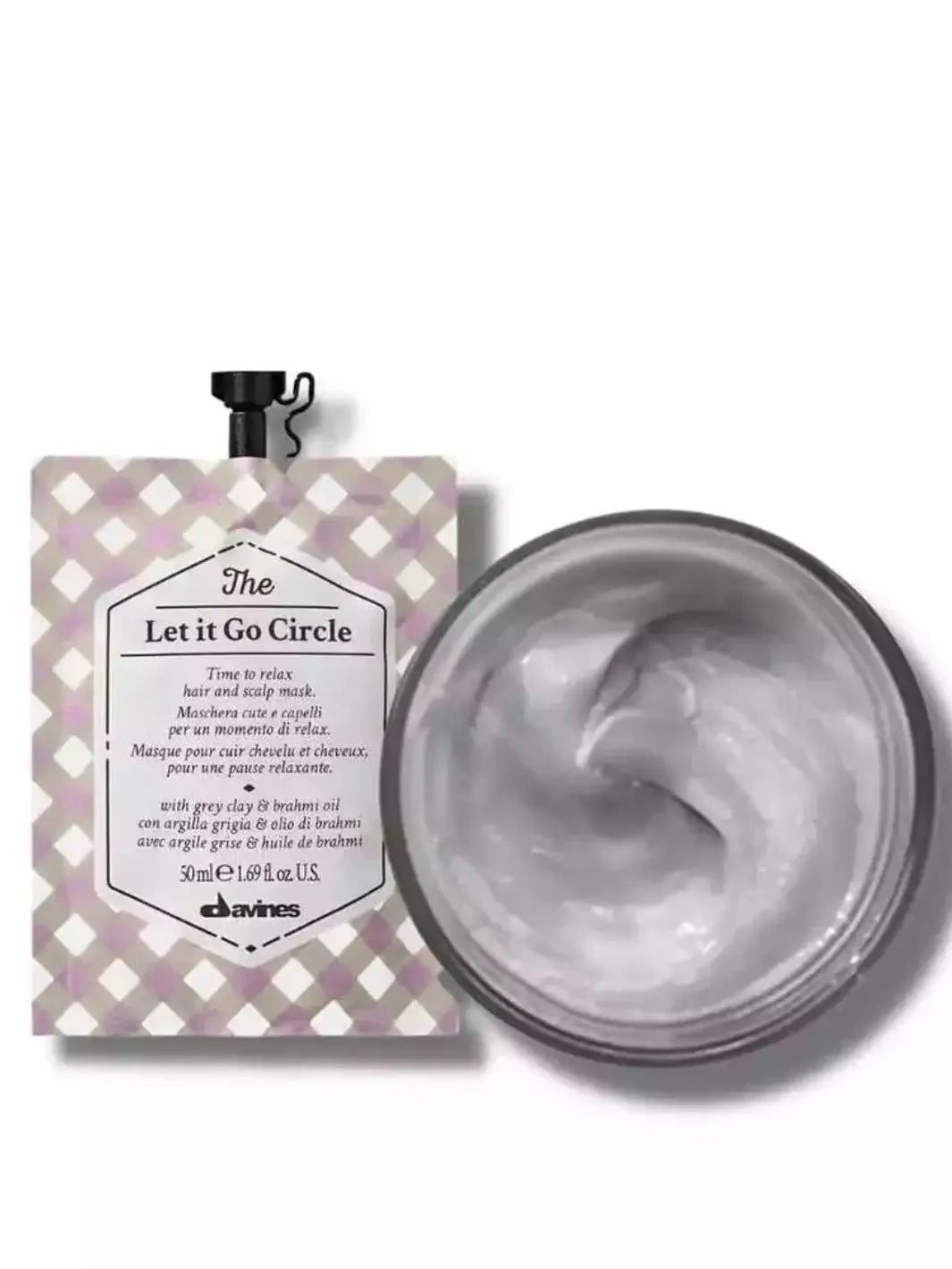 A checkered pouch of Davines Let it Go Circle of Chronicles Hair Mask is displayed next to an open jar filled with swirling grey cream | Twentyseven Toronto