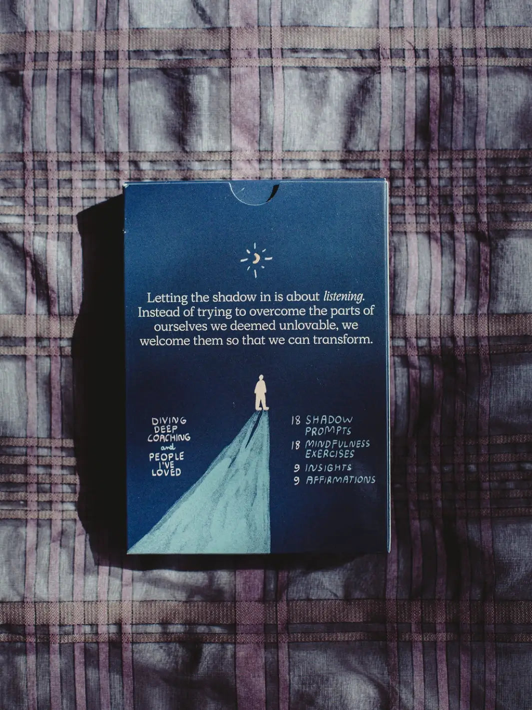 The back of the outer box for the Letting Your Shadow In Deck from People I've Loved outlines its contents, showing it includes shadow prompts, mindfulness exercises, insights, and affirmations | Twentyseven Toronto