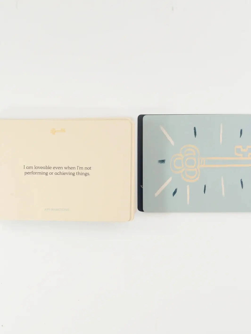 An affirmation card reading "I am loveable even when I'm not performing or achieving things" lies next to a gold key graphic from the Letting Your Shadow In Deck from People I've Loved | Twentyseven Toronto