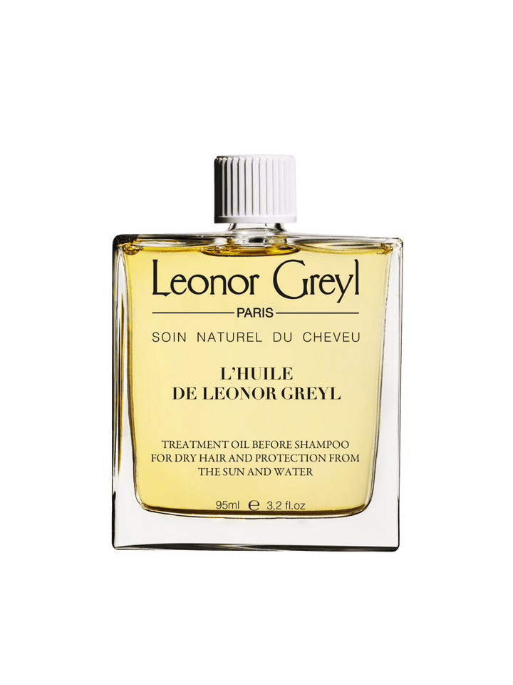 Glass bottle of gold liquid 'L’Huile de Leonor Greyl' by Leonor Greyl on a transparent background | Twentyseven Toronto