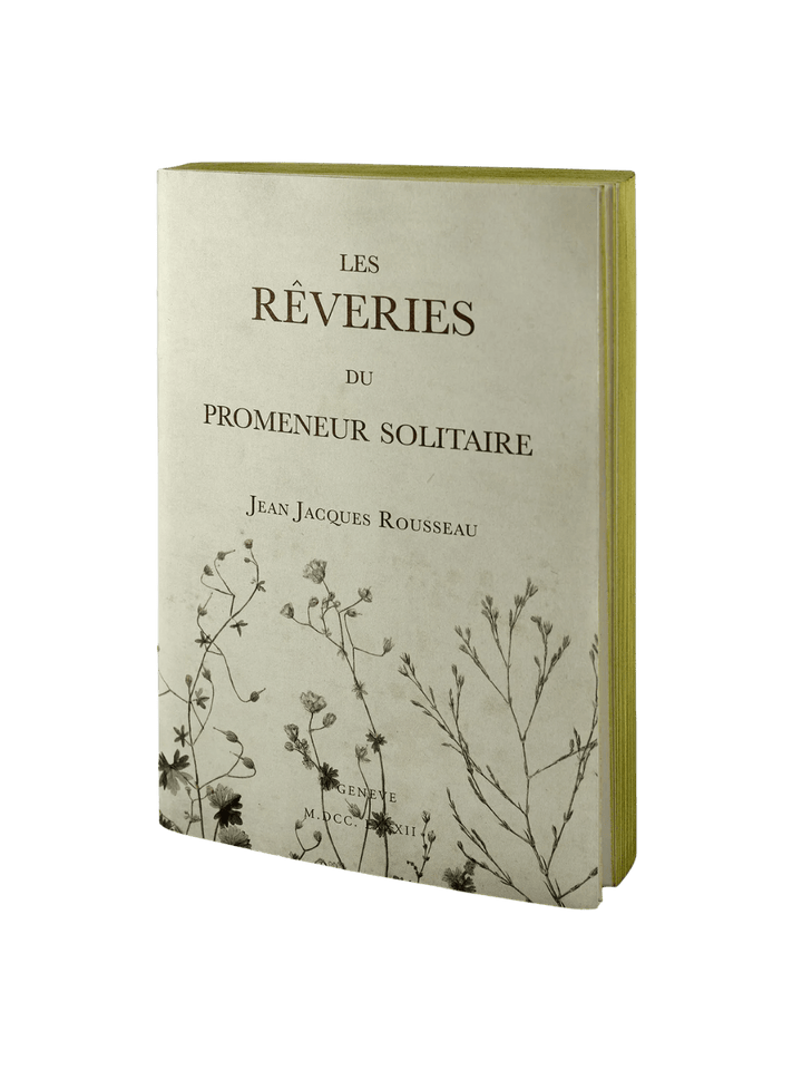 The front cover of a cream-colored notebook from the Les Reveries from the Slow Design Libri Muti collection features the title "LES RÊVERIES DU PROMENEUR SOLITAIRE" by Jean Jacques Rousseau, adorned with delicate botanical illustrations on the bottom | Twentyseven Toronto