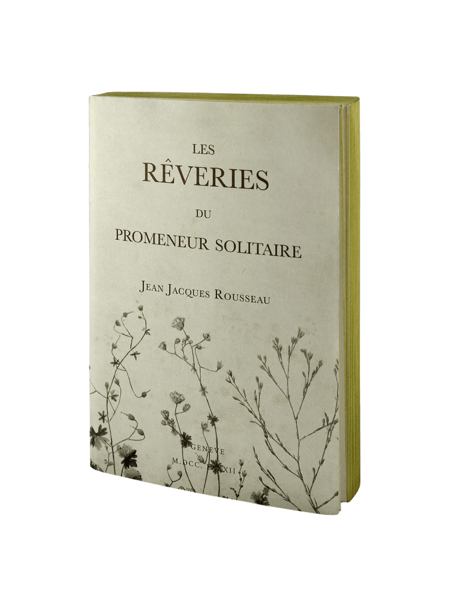 The front cover of a cream-colored notebook from the Les Reveries from the Slow Design Libri Muti collection features the title "LES RÊVERIES DU PROMENEUR SOLITAIRE" by Jean Jacques Rousseau, adorned with delicate botanical illustrations on the bottom | Twentyseven Toronto