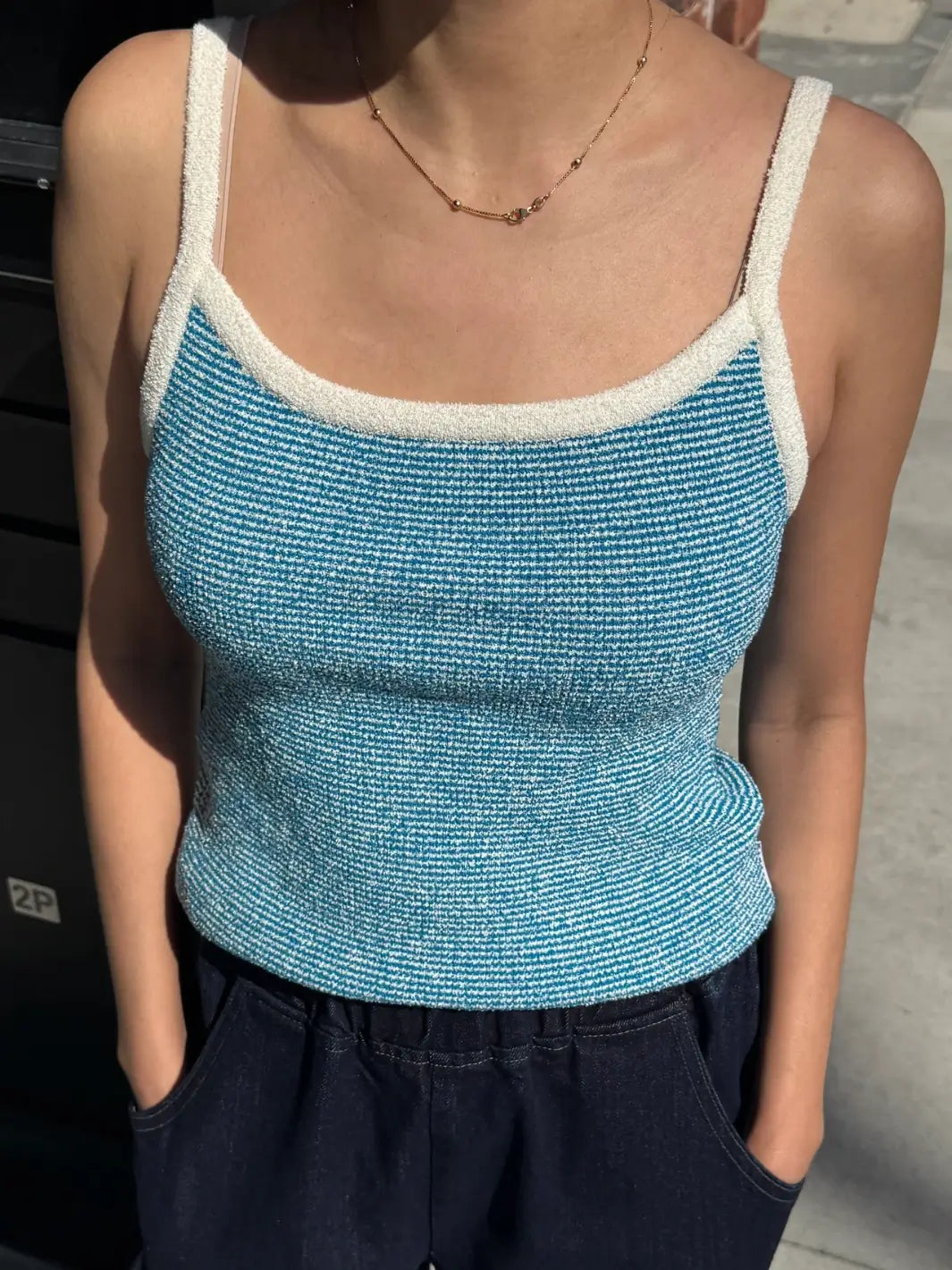 Person wearing a textured light blue 'Lily Sweater Cami' tank top in 'Blue Stripe' design with white trim from Le Bon Shoppe | Twentyseven Toronto