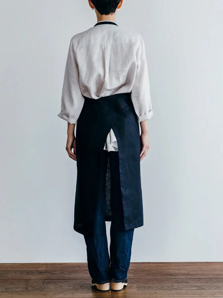 The back view of the Linen Full Apron in Navy from Fog Linen Work highlights the adjustable neck strap and secure waist tie | Twentyseven Toronto