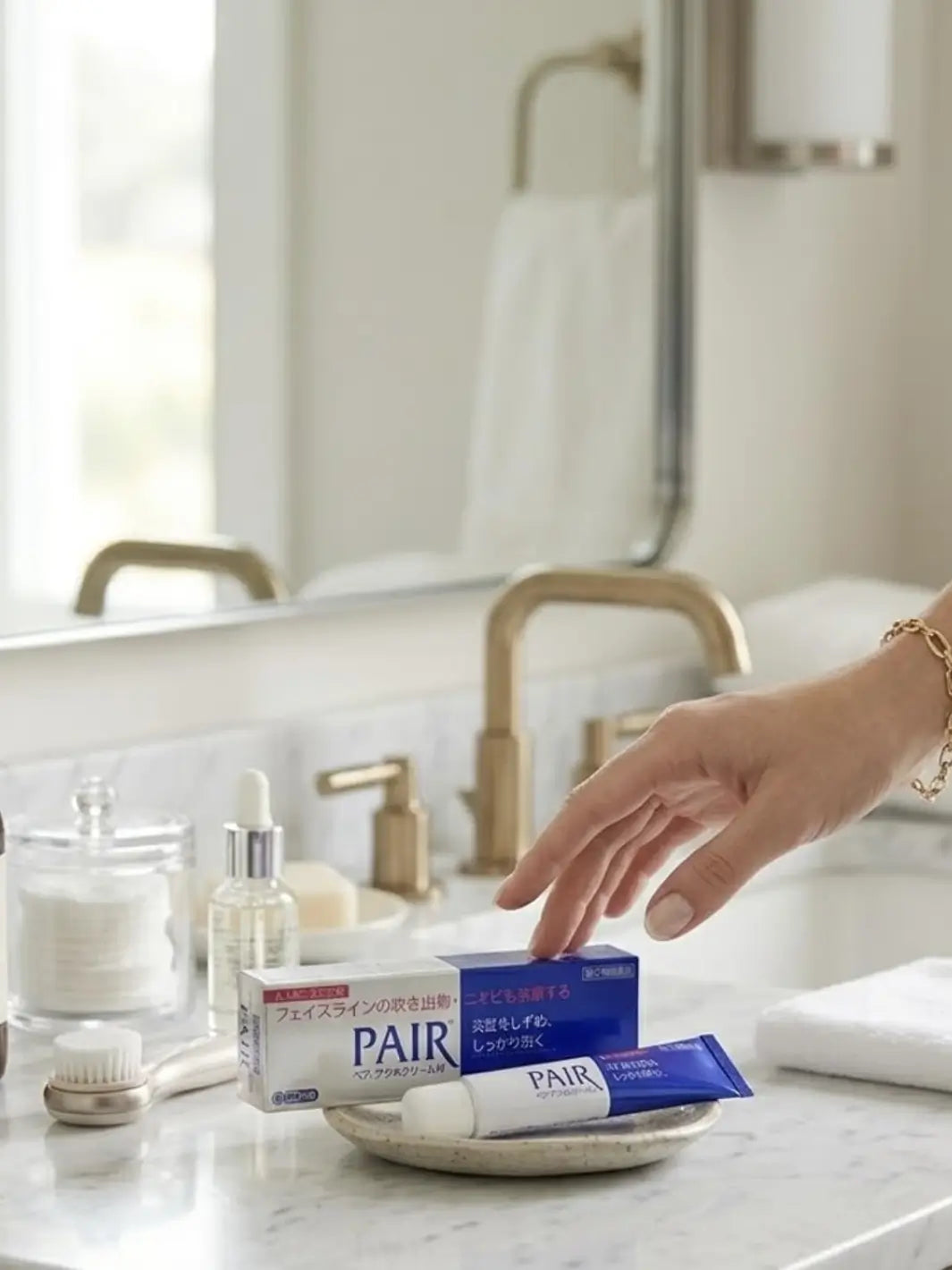 Hand reaching for Blue and silver Lion Pair Acne Cream 24g tube in a bathroom setting | Twentyseven Toronto