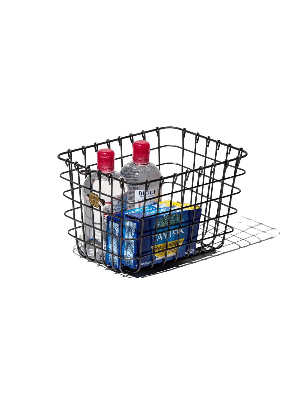 The Locker Basket - Medium from Puebco is holding personal care products and two clear bottles with red caps | Twentyseven Toronto