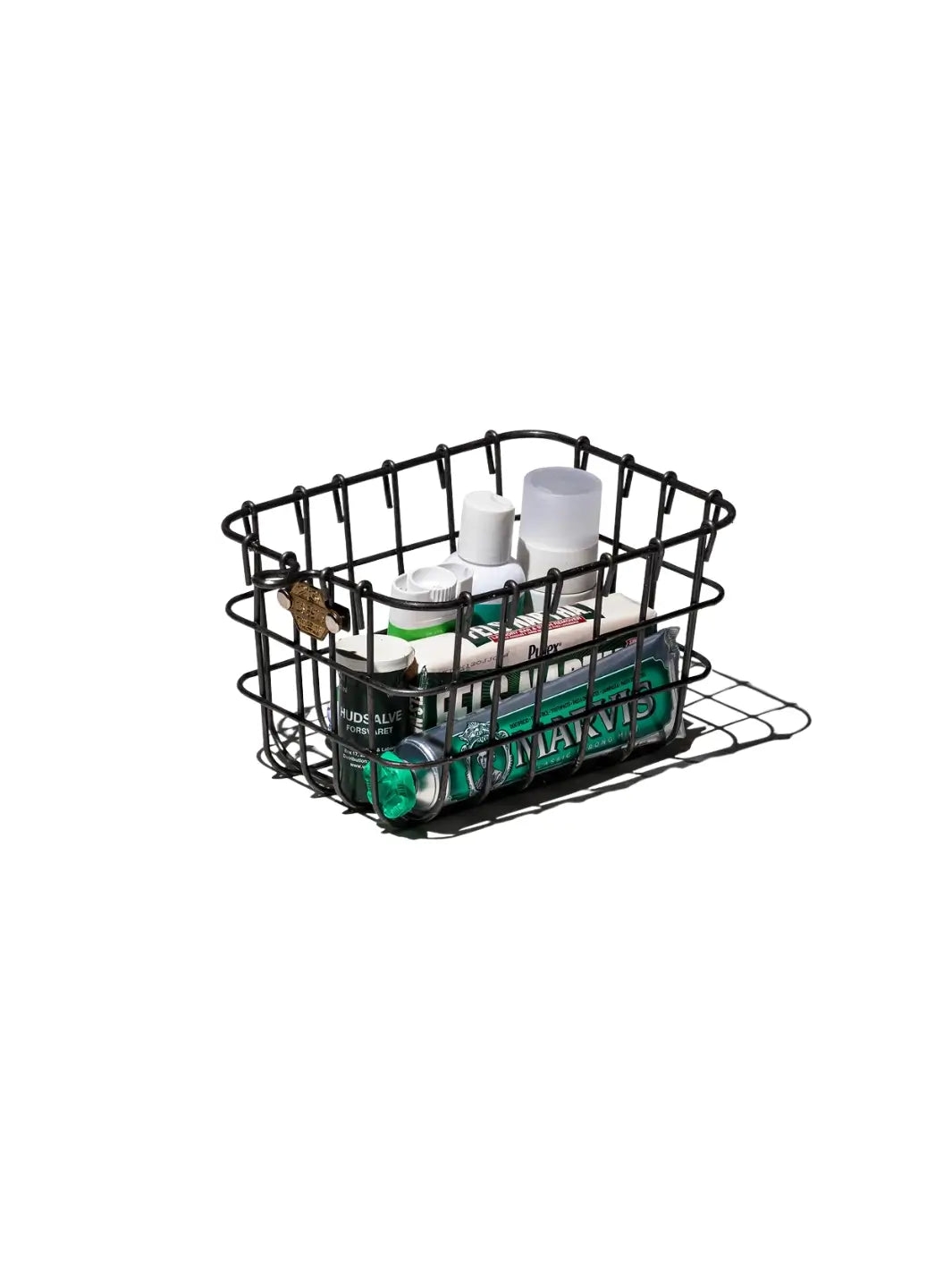 A wire Locker Basket - Small from Puebco is filled with various toiletries, including a tube of Marvis toothpaste | Twentyseven Toronto
