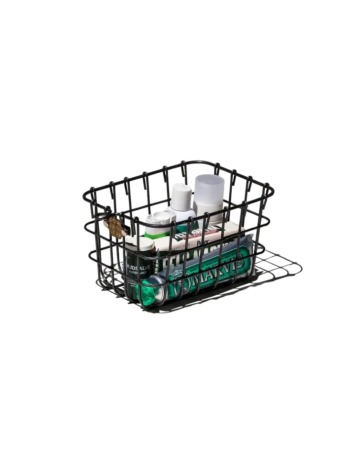 A wire Locker Basket - Small from Puebco is filled with various toiletries, including a tube of Marvis toothpaste | Twentyseven Toronto