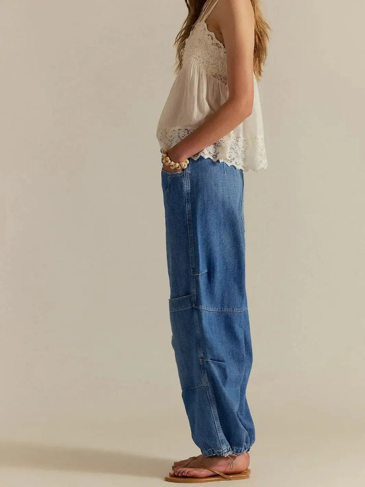 A side profile view showcases the straight, wide-leg silhouette and mid-leg cargo panel detailing of the Free People Logan Cinched Cargo Jeans - Harper | Twentyseven Toronto