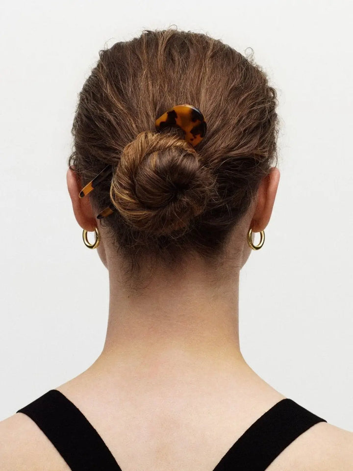 Back view of a person with a bun hairstyle featuring a green French hair pin in 'Meadow' from Machete on a white background | Twentyseven Toronto