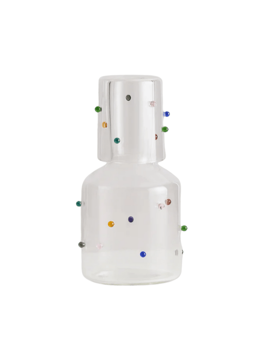 White 'Madame Pomponette' carafe from Maison Balzac with colorful decorative glass beads on a transparent background | Twentyseven Toronto