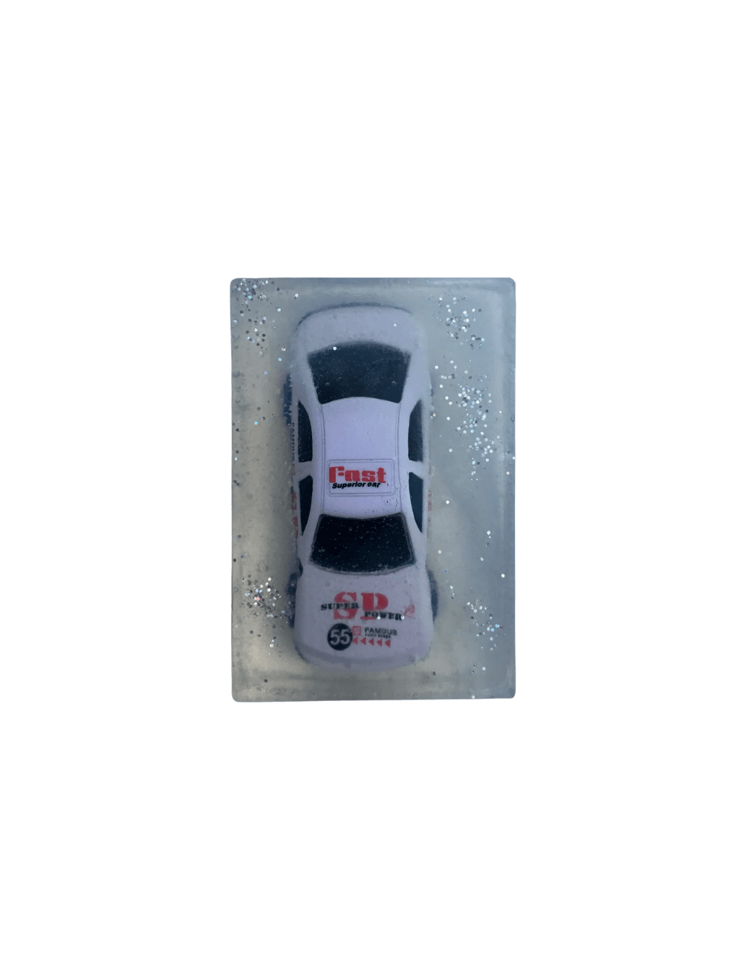 A rectangular bar of clear Cavancha Magic Glitter Soap - Cars embedded with a white toy race car and surrounded by silver glitter sparkles against a transparent background | Twentyseven Toronto