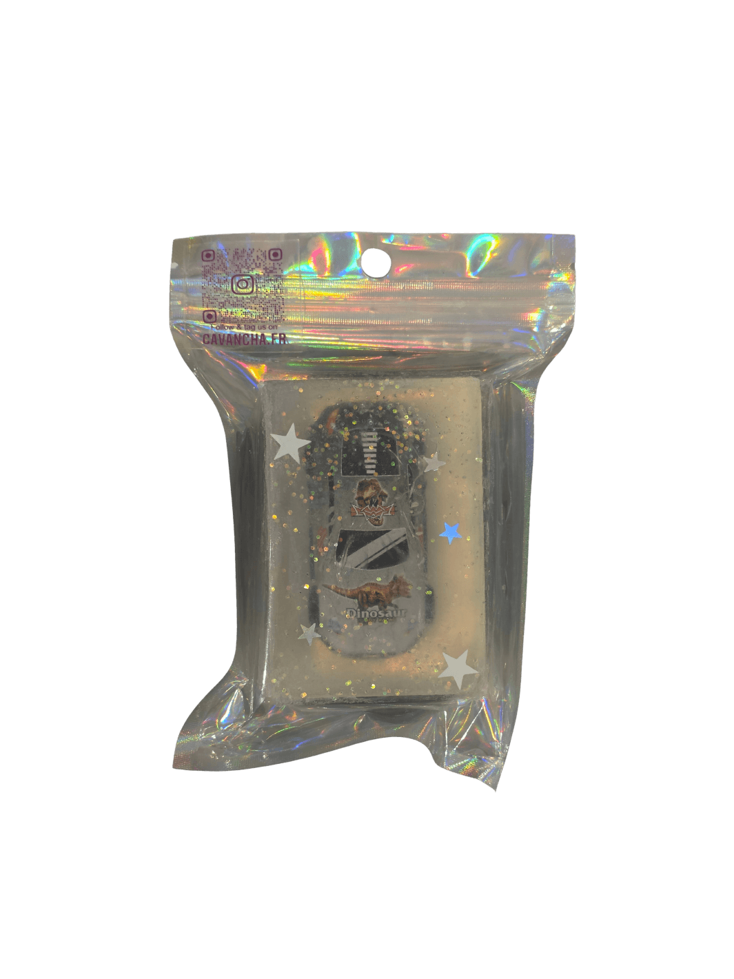 A clear bar of Cavancha Magic Glitter Soap - Cars, containing a small toy race car with dinosaur graphics embedded alongside loose star glitter, packaged inside a shiny holographic pouch | Twentyseven Toronto