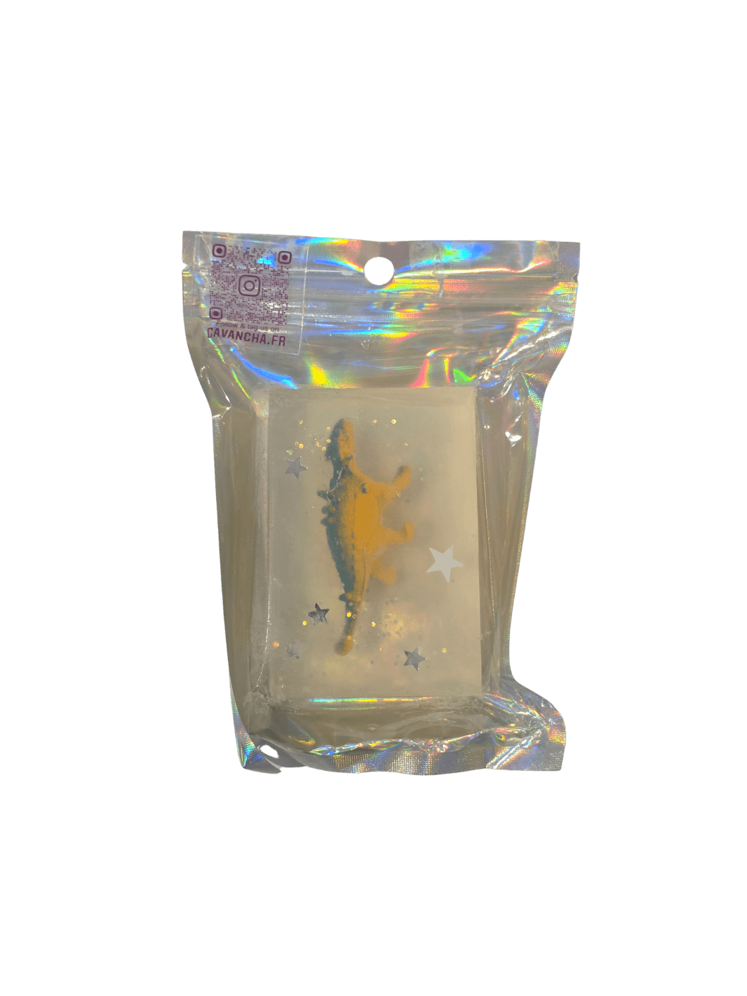 A clear bar of Cavancha Magic Glitter Soap - Dinos, containing a small yellow dinosaur figurine and embedded star glitter, packaged inside a shiny holographic pouch | Twentyseven Toronto