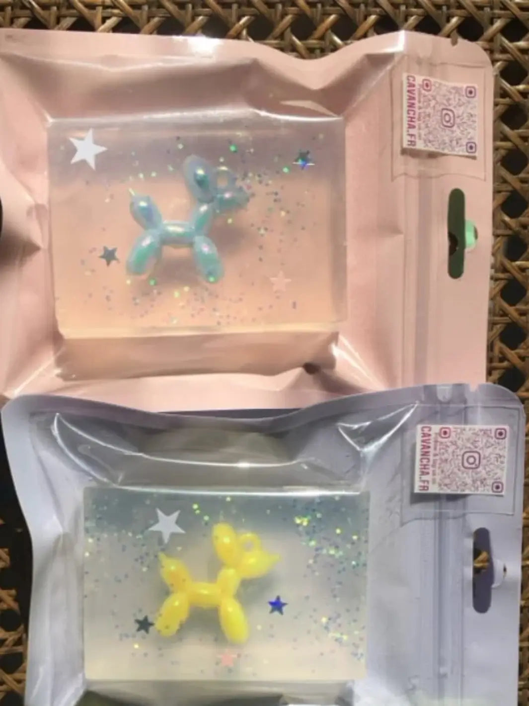 Two packaged bars of Cavancha Magic Glitter Soap - Jeff Koons Balloon Dog are shown together, one revealing an embedded light blue toy figure and the other featuring a bright yellow toy figure | Twentyseven Toronto