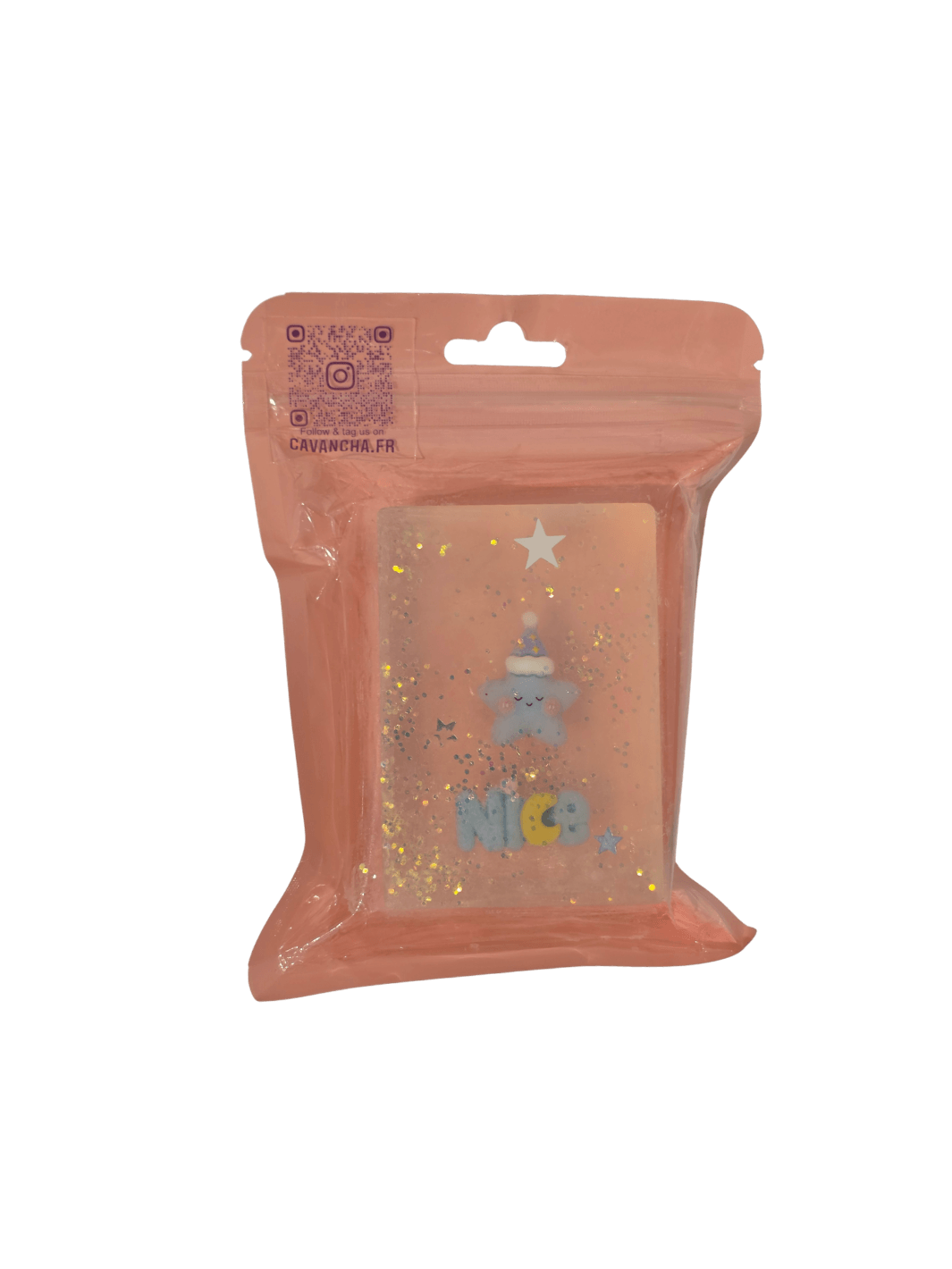 A clear bar of Cavancha Magic Glitter Soap - Kawaii Dreams, embedded with a sleeping blue star character wearing a nightcap, the word "NICE," and loose star glitter, packaged inside a dusty pink pouch | Twentyseven Toronto
