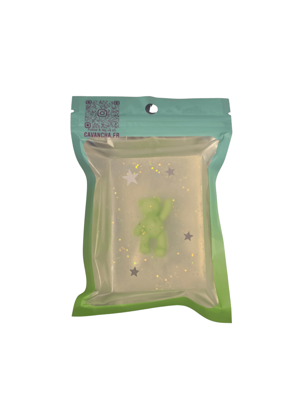 A clear bar of Cavancha Magic Glitter Soap - Teddy, embedded with a small green teddy bear figure and silver star glitter, packaged inside a teal pouch | Twentyseven Toronto