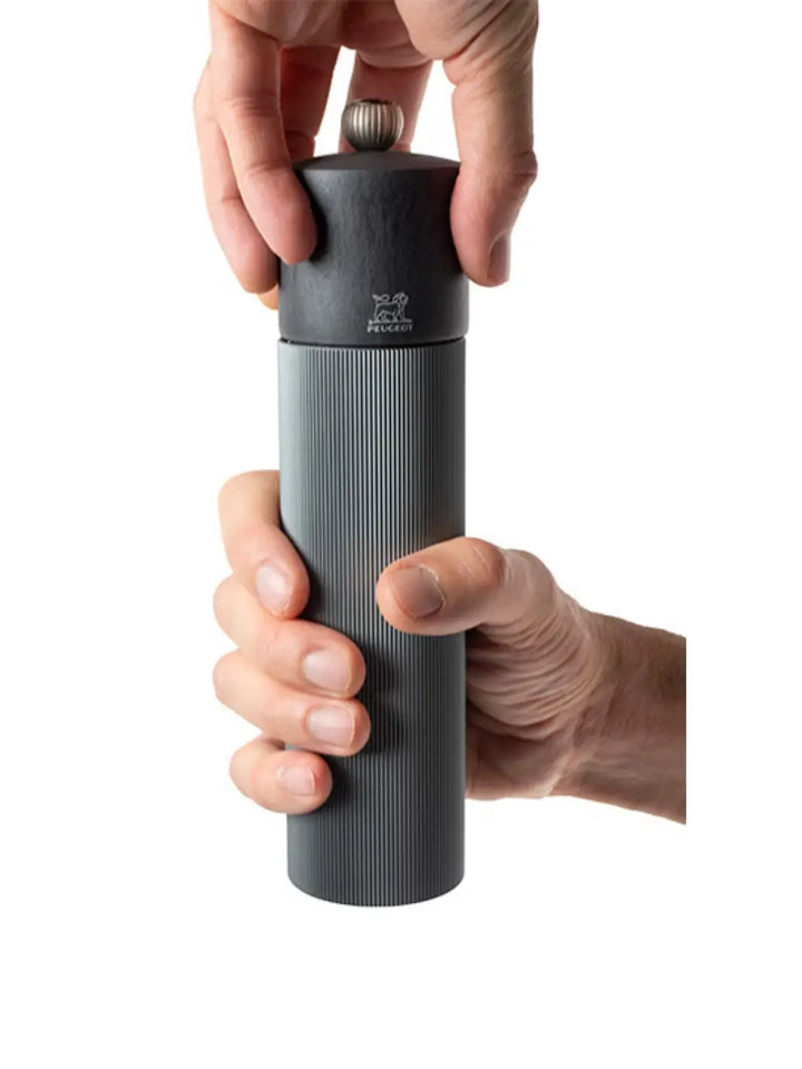 Hand holding 'Manual Pepper Mill Aluminum Wood in Carbon' black pepper grinder on a white background | Twentyseven Toronto