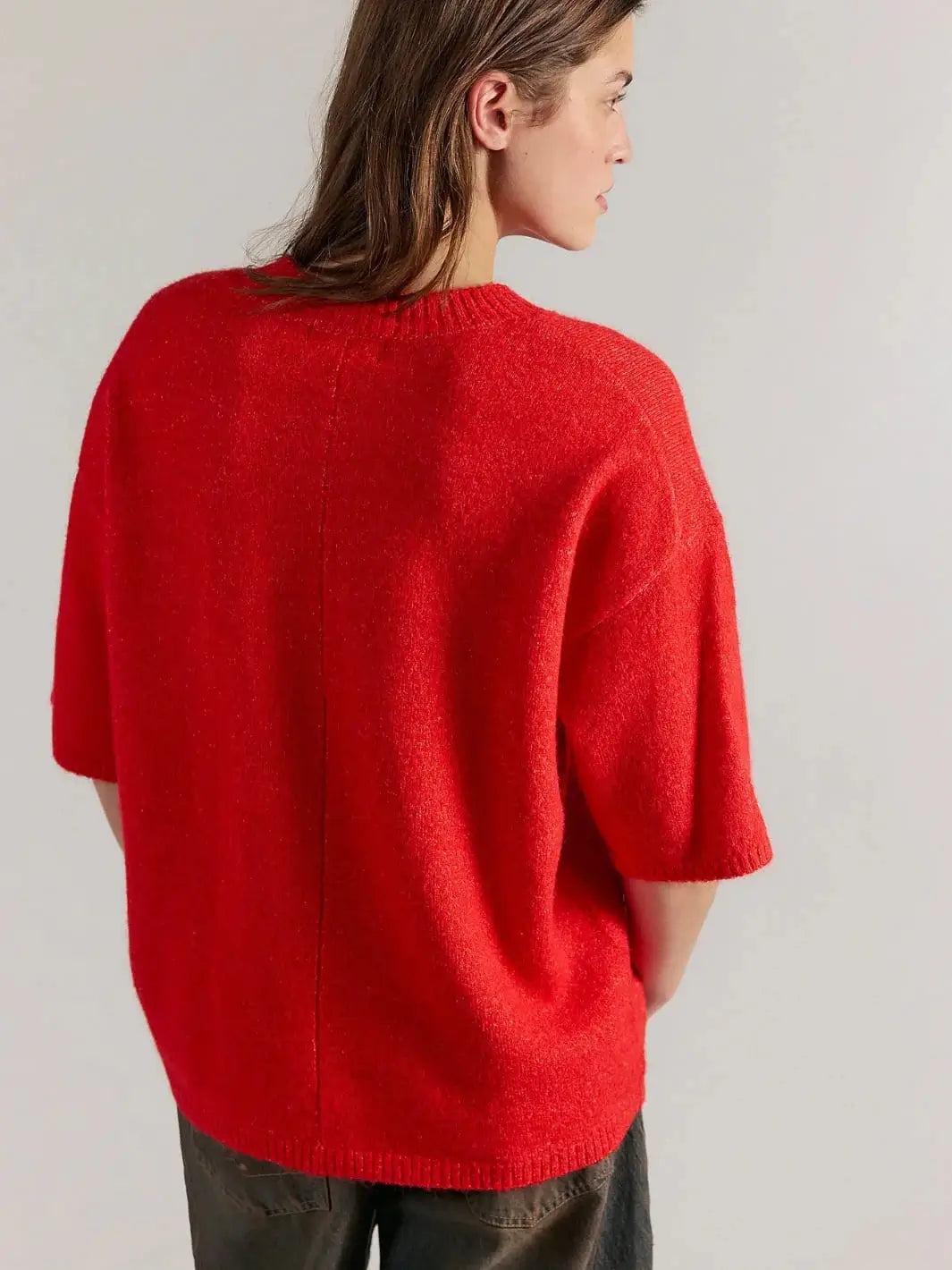 A three-quarter rear view displays the vertical center-back seam and relaxed, short-sleeve construction of the Free People Margot SoftSpun Sweater Tee in Cherry Pop Melange | Twentyseven Toronto