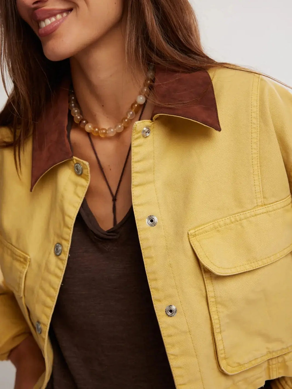 A close-up front view highlights the textured brown collar, snap-button closure, and prominent chest flap pockets of the cropped Free People Martha Workwear Applique Jacket in Rattan | Twentyseven Toronto