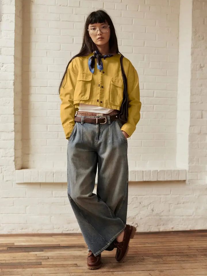 A full-length studio shot displays a model wearing the buttoned-up Free People Martha Workwear Applique Jacket in Rattan styled with a neck scarf, a white tee, and wide-leg blue jeans | Twentyseven Toronto