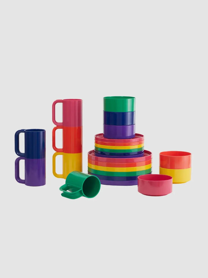 A full colourful dining collection displayed against a grey background, featuring stacked mugs, bowls, small plates from the Heller Max Dinnerware Set in Rainbow | Twentyseven Toronto