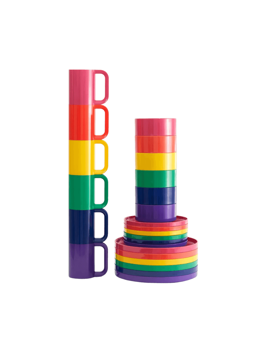 A towering stack of the Heller Max Dinnerware Maxmug in Rainbow - Set of 6 stands next to a matching rainbow stack of dinnerware plates, salad plates, and bowls against a transparent background | Twentyseven Toronto