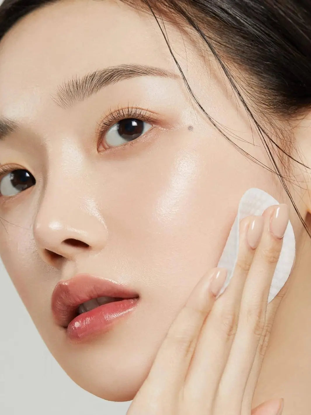 Woman applying the Medicube Zero Pore Pad to her face | Twentyseven Toronto