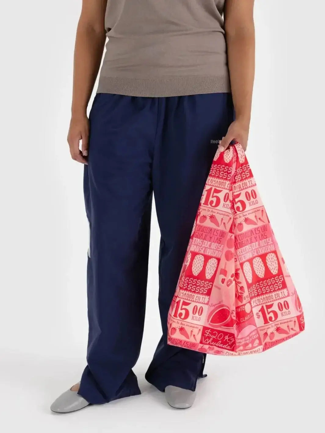 A person stands holding the Baggu Mercado Bag down by their side, showcasing its pink grocery-market-inspired print | Twentyseven Toronto