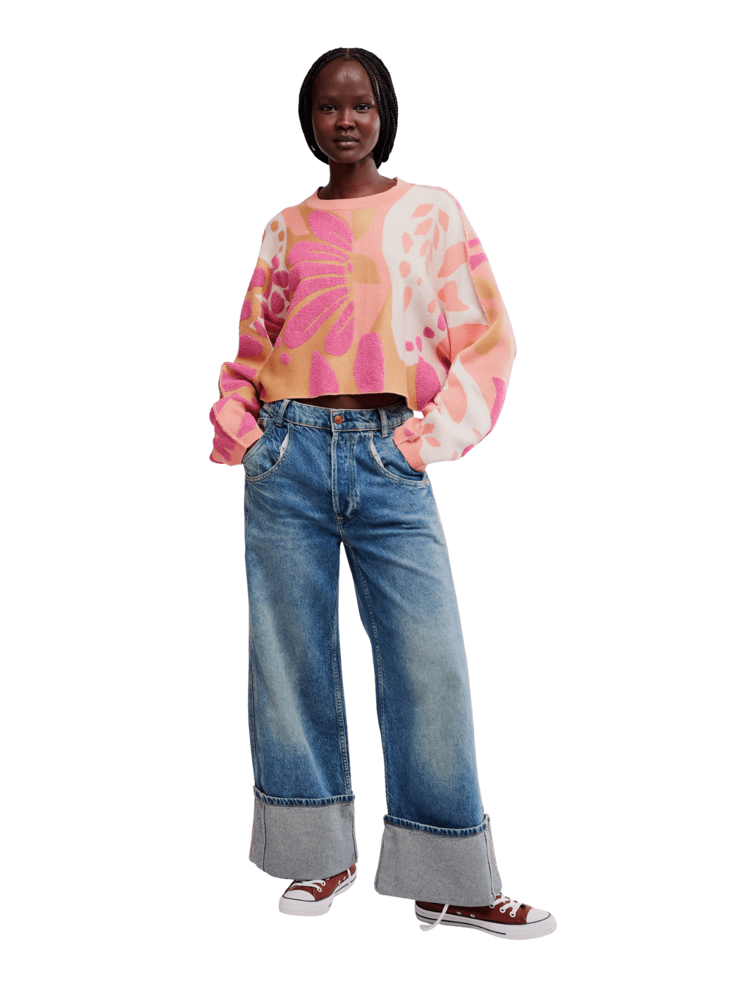 Full-length view of a model wearing the Free People Mia Pullover in Coral Kiss Combo styled with cuffed blue jeans and sneakers | Twentyseven
