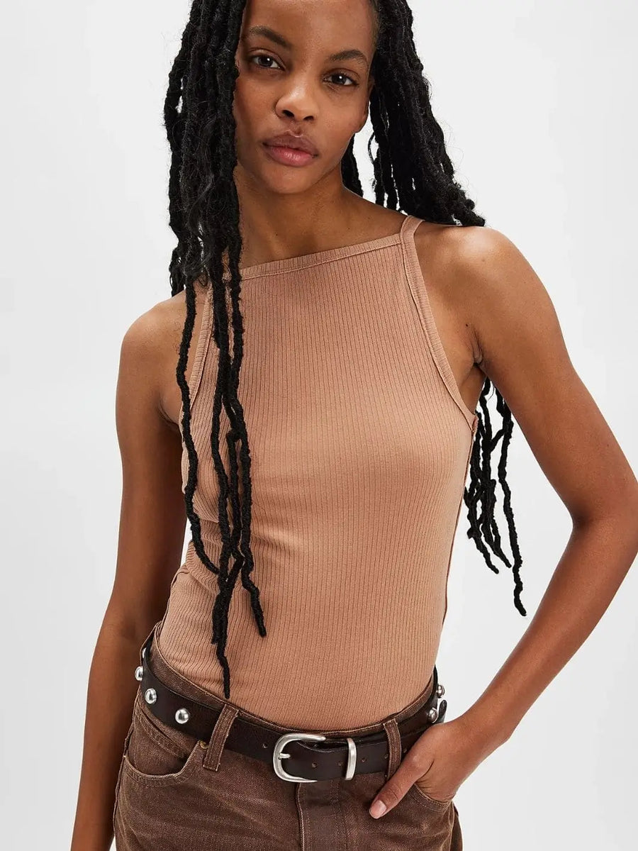 A front view showcases the high square neckline and ribbed texture of the Free People Mia Tank - Macchiato paired with brown studded denim | Twentyseven Toronto