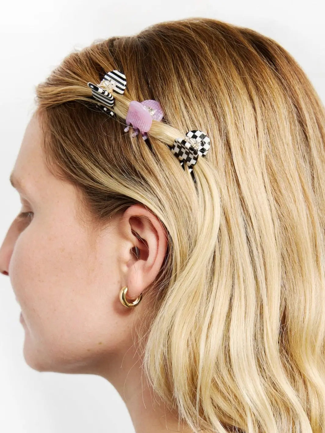 A side profile shows a model with blonde hair styling a section of her hair with three different CHUNKS Micro Claws in Geo | Twentyseven Toronto