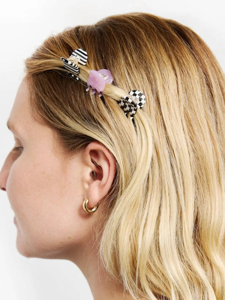 A side profile shows a model with blonde hair styling a section of her hair with three different CHUNKS Micro Claws in Geo | Twentyseven Toronto