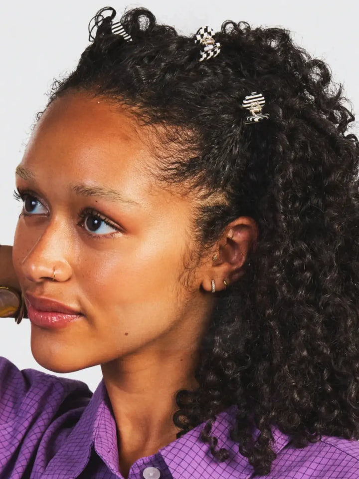 A model with dark, curly hair styles her pulled-back hair with several patterned CHUNKS Micro Claws in Geo | Twentyseven Toronto