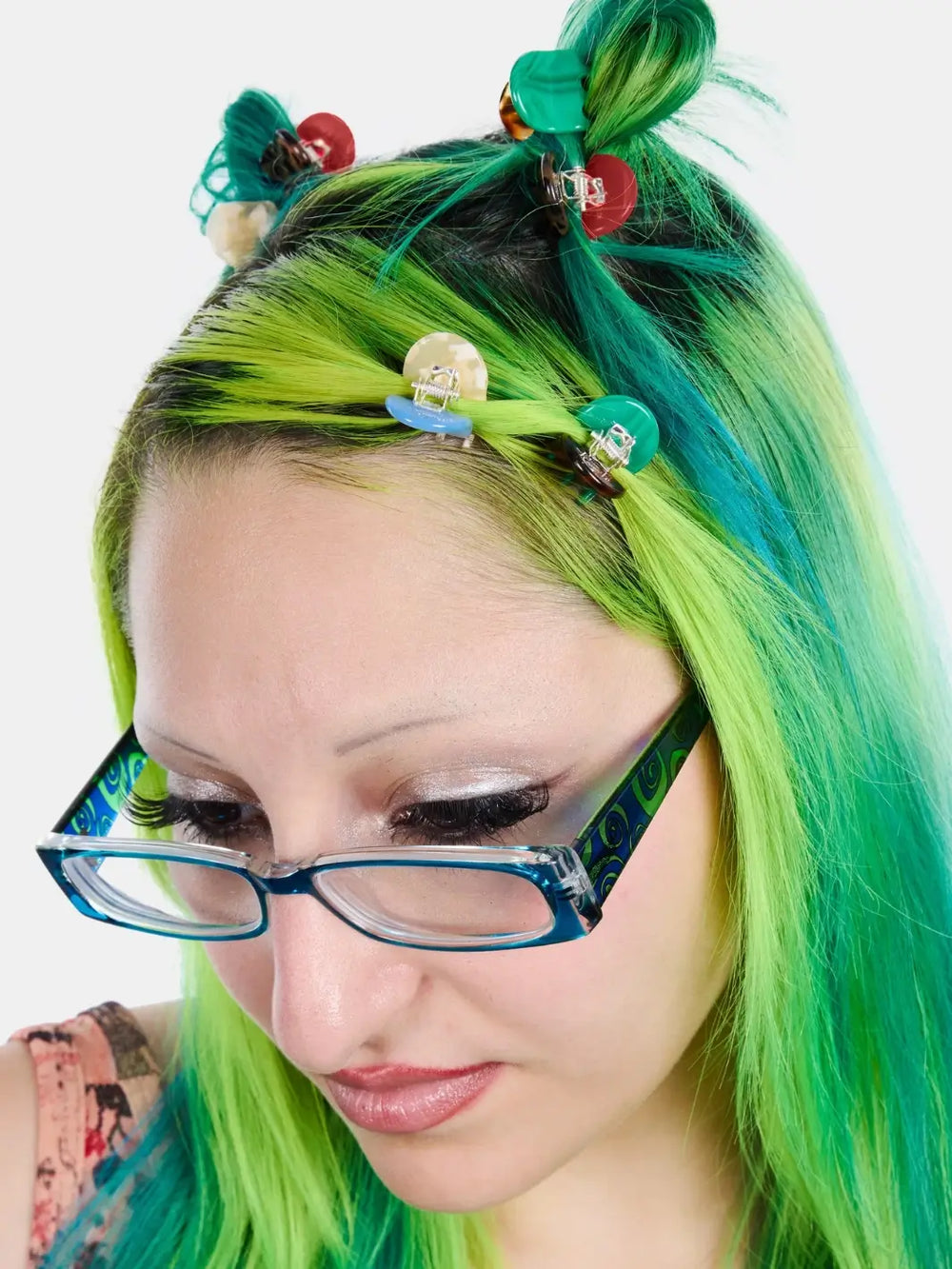A person with vibrant green and blue hair wearing several small hair clips, including the Chunks Hairclips Micro Claws in Hot Mama set pinned into their half-up hairstyle | Twentyseven Toronto