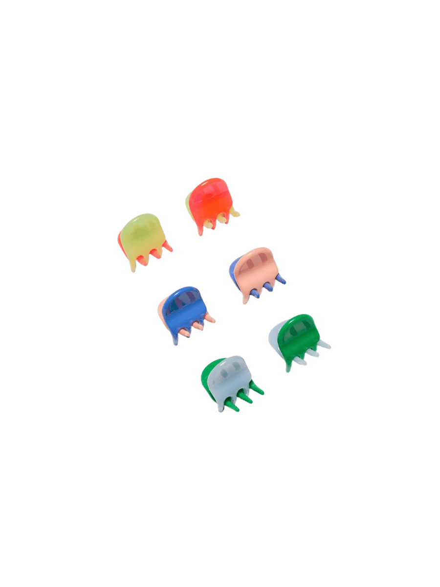 Six vibrant, translucent claw clips from the Chunks Hairclips Micro Claws in Play set are arranged neatly on a transparent surface | Twentyseven Toronto