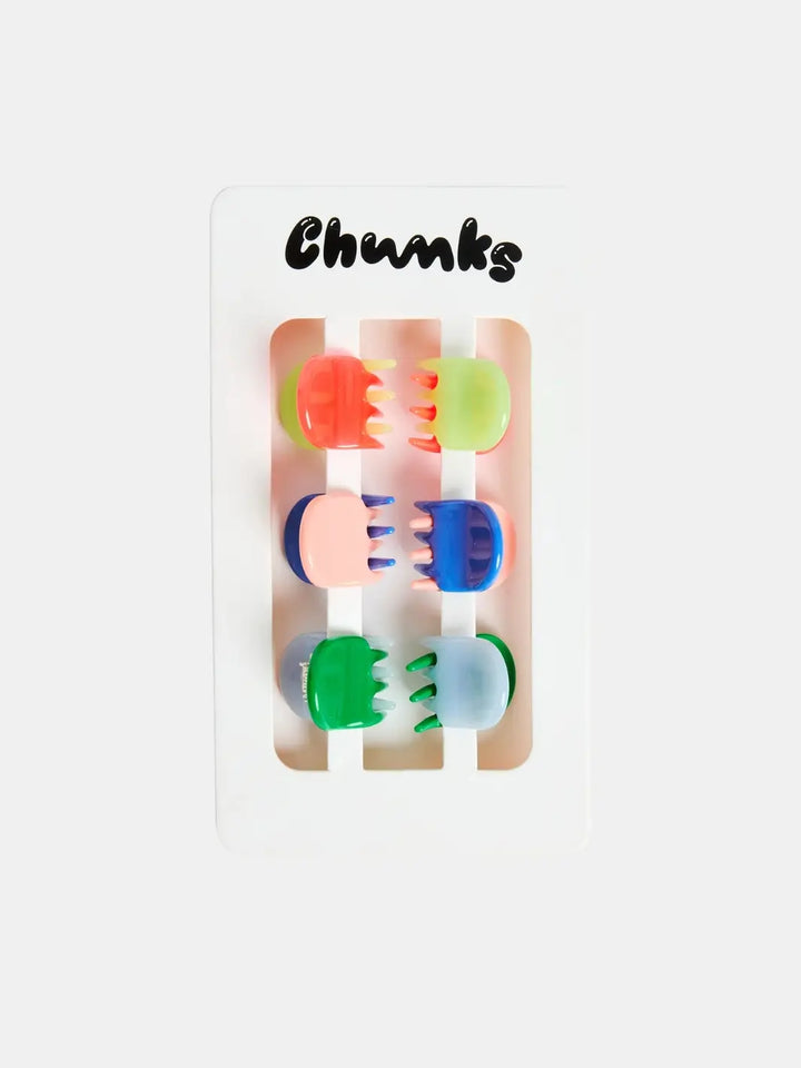 Six small, multi-colored claw clips from the Chunks Hairclips Micro Claws in Play set are displayed vertically in pairs on a white cardboard backing sheet with the Chunks logo | Twentyseven Toronto