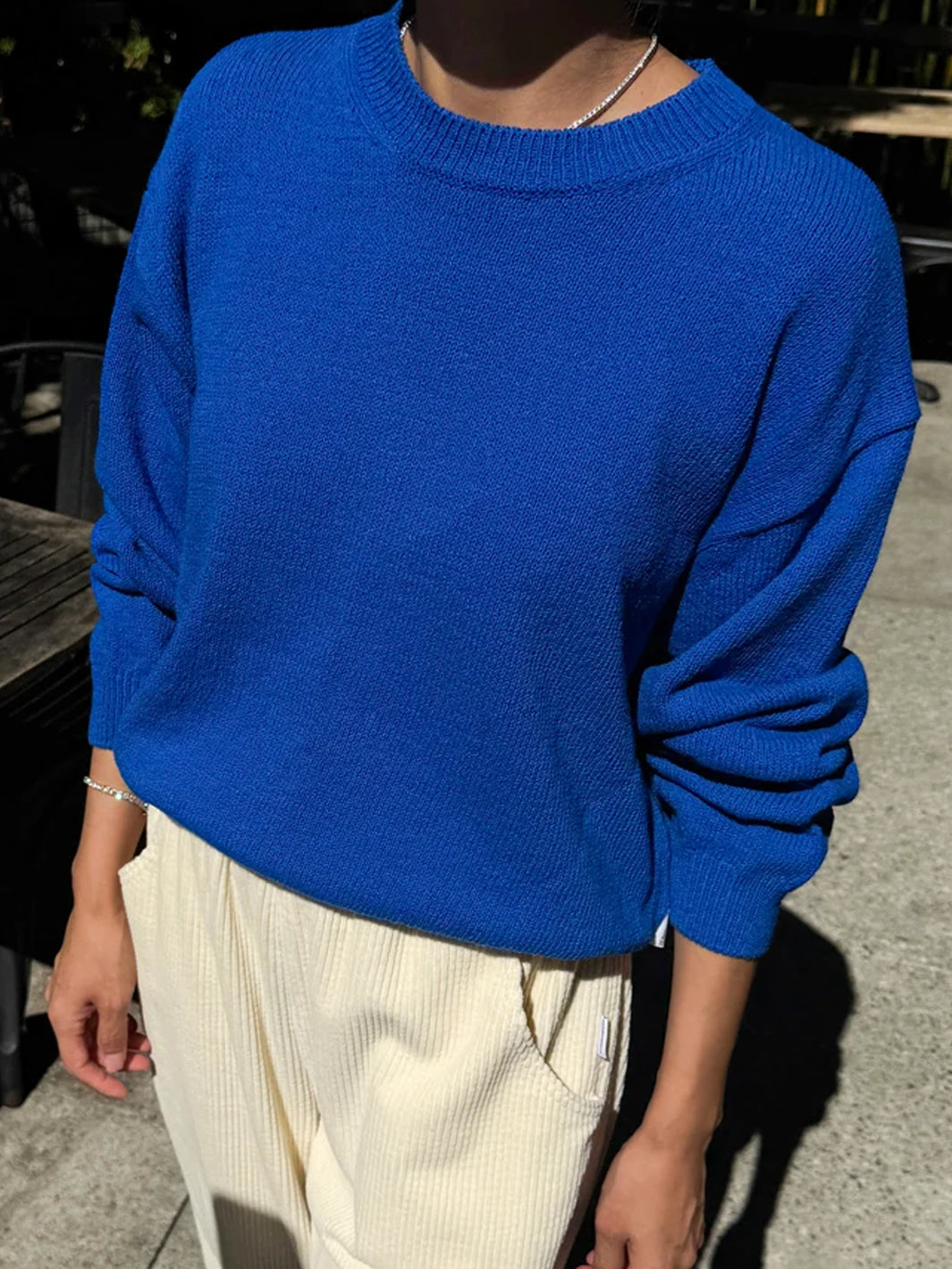 Front view of model wearing the Le Bon Shoppe Milo Cotton Sweater in Cobalt Blue with cream pants | Twentyseven Toronto