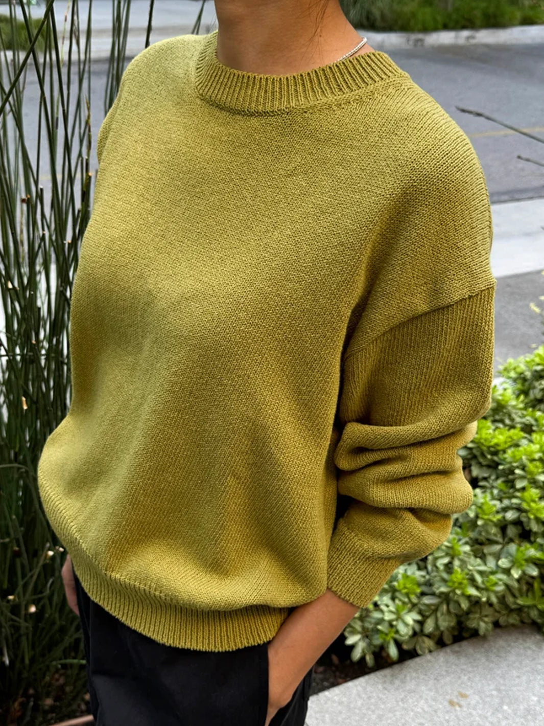 Side view of model wearing the Le Bon Shoppe Milo Cotton Sweater in Golden Olive, showing the relaxed fit | Twentyseven Toronto