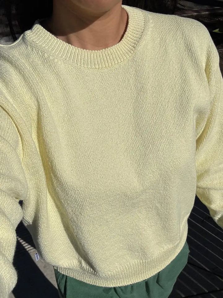 Light yellow 'Milo Cotton Sweater' in 'Lemonade' from Le Bon Shoppe worn by a person in an outside setting | Twentyseven Toronto
