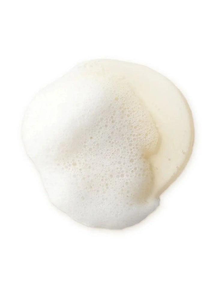 A rich, white foam lather generated by the liquid formula of Bathing Culture Mind & Body Wash - Meadow Vision against a white background | Twentyseven Toronto