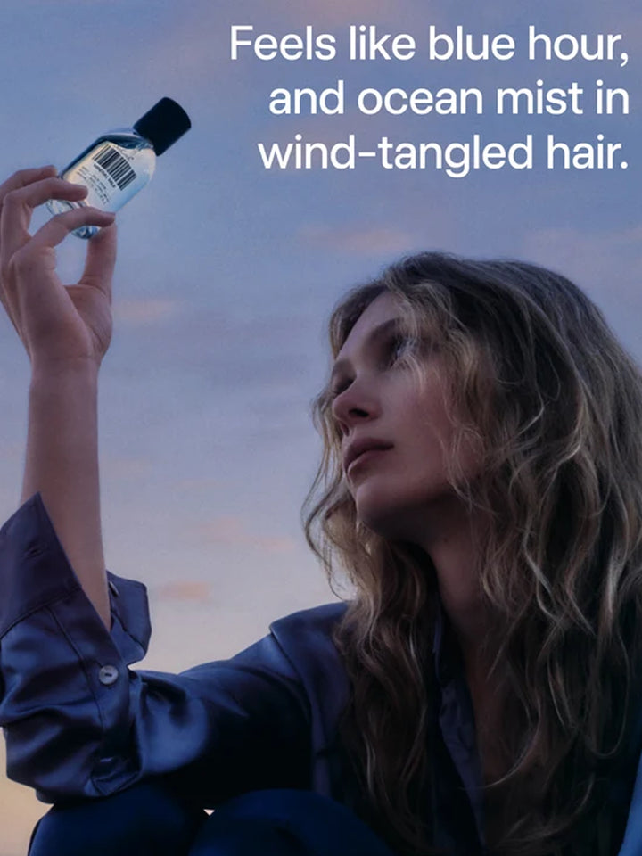 DedCool Mineral Milk Eau de Parfum held against a blue-hour sky with ocean-inspired campaign text | Twentyseven Toronto