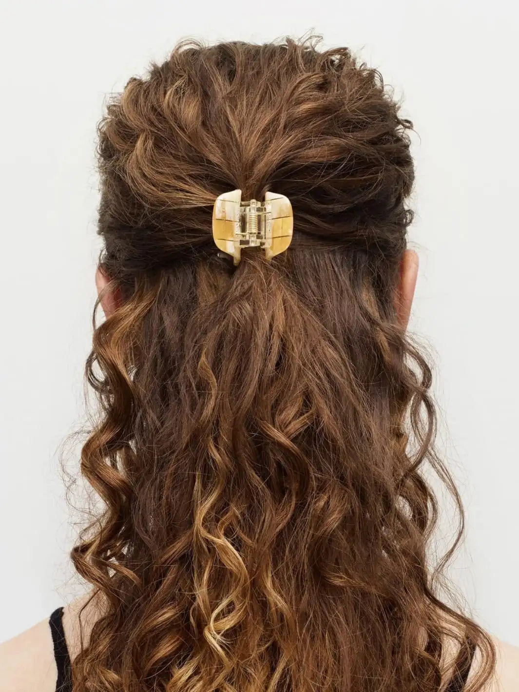 Woman with wavy hair wearing a yellow mini claw hair clip by MACHETE on a white background | Twentyseven Toronto